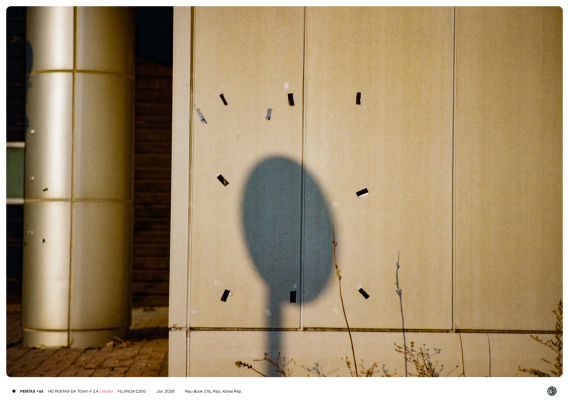 포스터가 붙여져 있던 자리 한 가운데 표지판의 그림자가 비치는 모습.