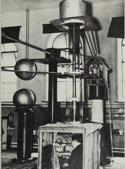 a black and white photo of a scientist in a mystery box with many mysterious mechanical elements around him