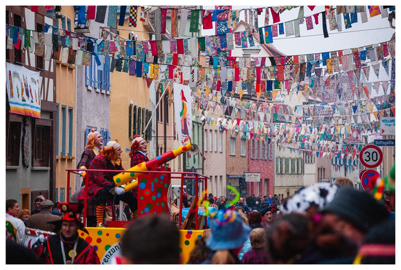 Clowns mit Konfettikanone bombadieren die Straße.