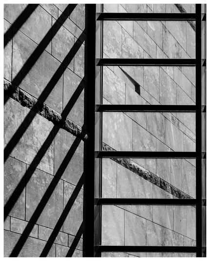 Fensterfront mit langen schatten und Fassadensteinen in Schwarz Weiß.