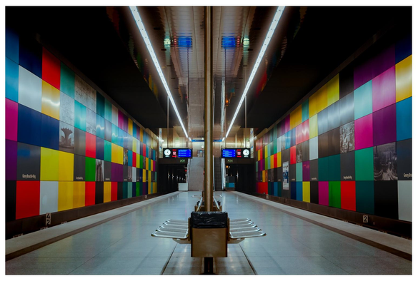 Blick in eine farbenfrohe U-Bahnstation. Streng symmetrisch aufgenommen. Alle Linien fluchtpunkten in einem Mittelpunkt.