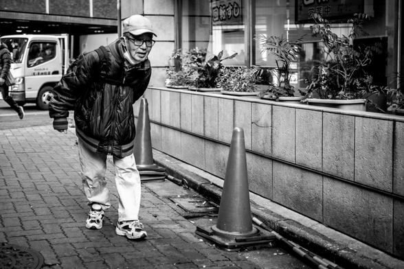 Home gran, mig encorvat, caminant pls carrers de Kabukicho (Tòquio)