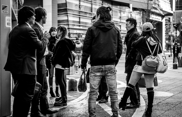 Grup d'homes i dones fumant en una cantonada de Kabukicho ben aviat al matí.