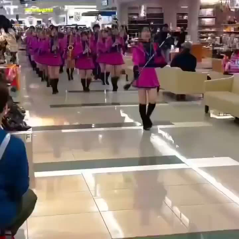 défilé d’une fanfare en rose sur un air entraînant aux instruments à vent