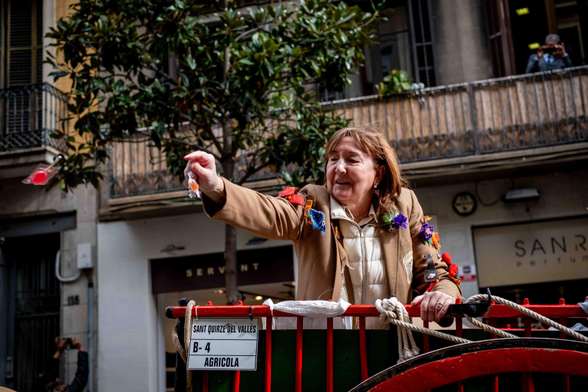 Dona gran llençant un caramel als vianants que presenciaven la cavalcada de Sant Medir, a Gràcia, Barcelona.
