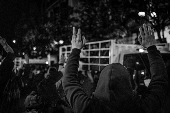 Jove aixeca les mans per intentar atrapar els caramels que llencen les colles de Sant Medir al carrer Gran de Gràcia.