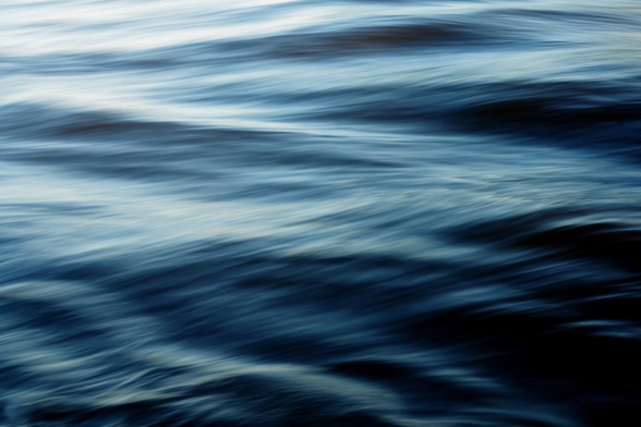 Leicht verwischte Nahaufnahme von Wasser in unterschiedlichen Blautönen von hell bis dunkel in Bewegung. 

A slightly blurred close-up of water in various shades of blue, ranging from light to dark, in motion. 