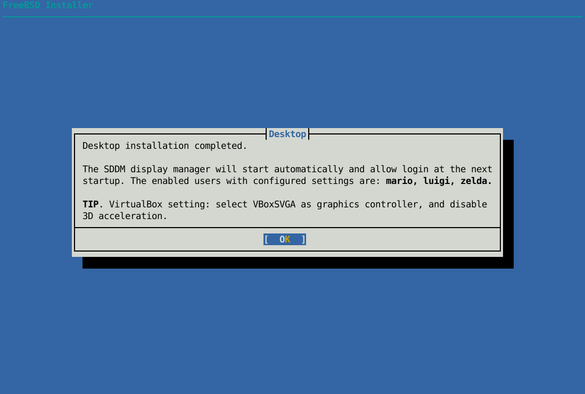 Text-based FreeBSD installer dialog with the title “Desktop installation completed.” The message explains that the SDDM display manager will start automatically at the next system boot and lists configured users. A tip suggests using the VBoxSVGA graphics controller and disabling 3D acceleration in VirtualBox. An “OK” button is highlighted at the bottom.