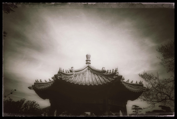 A moody, monochrome photo of the top of a Japanese pagoda, set against angry skies. Lots of glare and shadows. Right now, as I type this, it kinda looks like that too outside, as we head into a break from the rain.