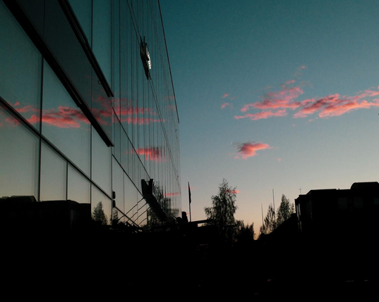 Pink clouds reflecting in glass facade