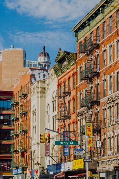 A white dome peeks out from a row of old mid-rise brick buildings