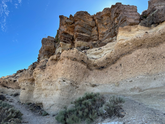 A multi-layered rock formation in a high-altitude mountain landscape. Despite the warm weather, small patches of ice could be seen in the deep shade.

