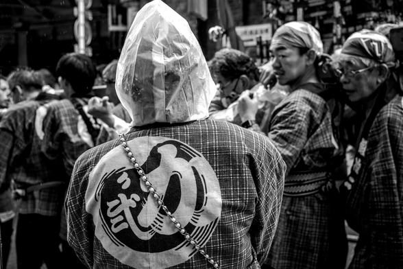 Participant del matsuri protegida de la pluja