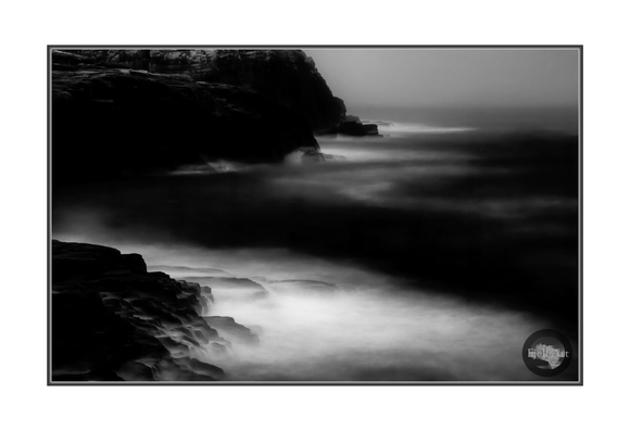 Long exposure on the dark and foggy morning. Rocks and waves.