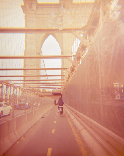 Going under the Gothic arches of Brooklyn bridge on a bike path. There's another rider in front of me