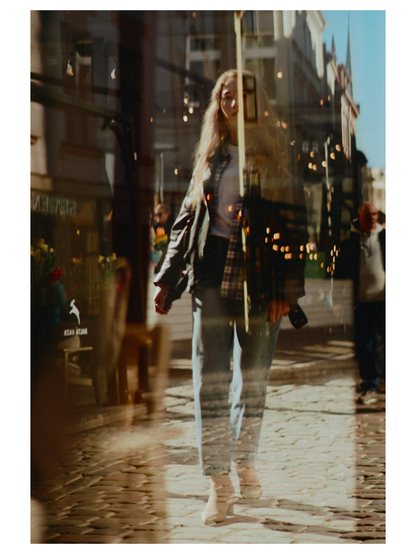 Portrait of a woman walking in old city covered in reflections and sun flares.