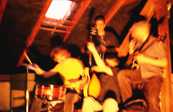 Blurred picture of the 4-piece band BEEAH playing their instruments.