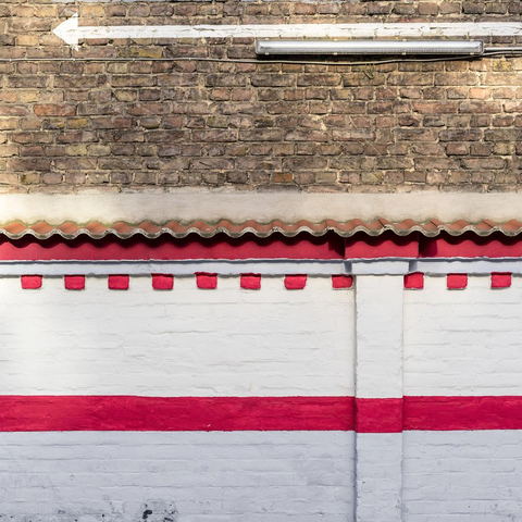 Cover artwork of the album, showing a freshly painted brick wall with intensive white and red patterns. On the top, there is an arrow pointing to the left.