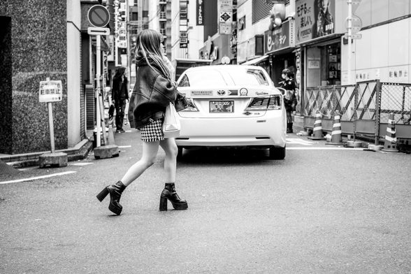 Dona amb minifaldilla i sabates de tacó alt travessant un carrer a Kabukicho (Tòquio)