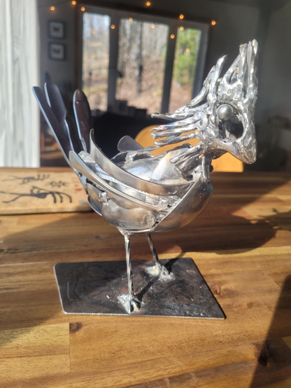 Un oiseau de type cardinal se tient au soleil. Son dos va avoir besoin de plus de plumes en effet. 

Remarquez autour de ses ailes, les résidus de ma méthodes de soudure à nettoyer. 