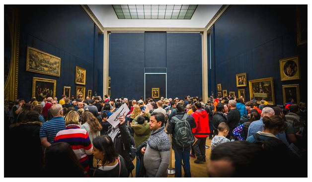 Blick in eine Halle des Louvre. Vorne Drölfzigtausend Menschen. Hinten ein Gemälde einer grinsenden Frau.