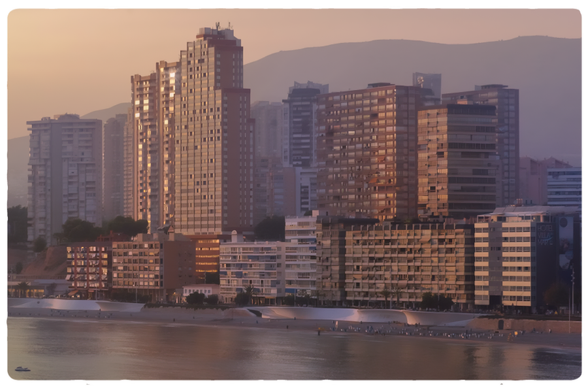 Blick auf vom Aussichtspunkt Balcó de la Mediterrània in Benidorm auf die Hoteltürme  an der Playa de Poniente. Alles im späten Abendlicht in Rosatönen. Im Vordergrund ruhiges Meer.