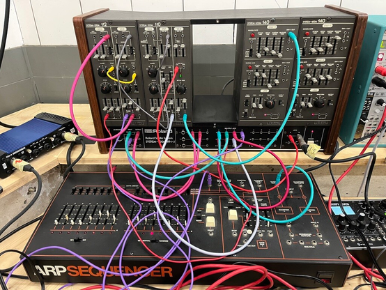 Closeup of a Roland System 100m and a ARP Sequencer with patch cables