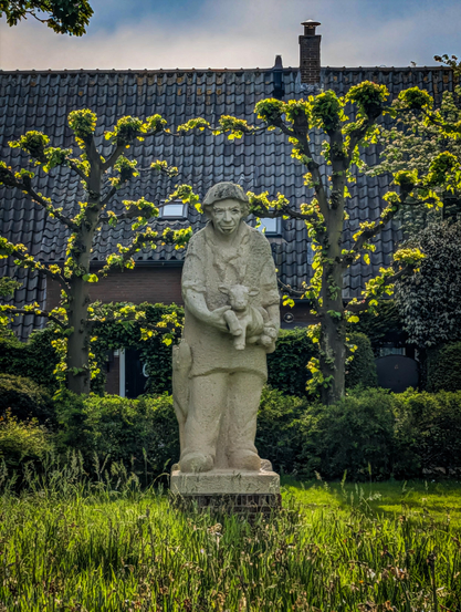 Lammert Herder, a shepherd from Laren, holding a lamb in his arms with his dog by his side.

A statue created by Willy Mignot.