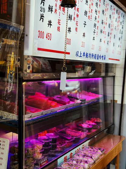 展示柜内有各种生鲜食材，背景是汉字菜单。