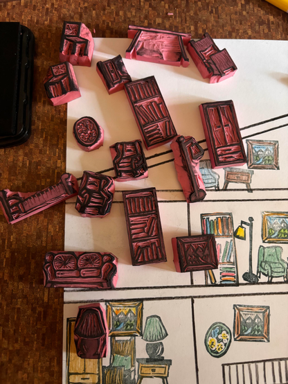 A collection of tiny stamps, depicting household furnishings, on top of a page with stamps that have been colored with colored pencil. 