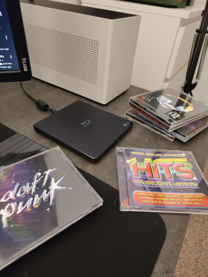 A picture of my desk, showing a bunch of CDs that I am currently ripping