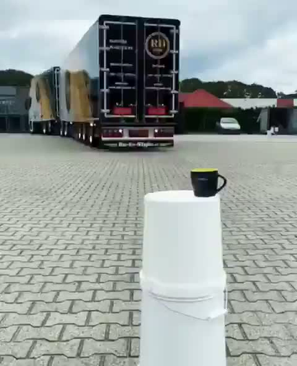un camion poids lourd manoeuvre en marche arrière et utilise ses suspensions pneumatiques pour immerger son sachet de thé dans le respect de la tradition