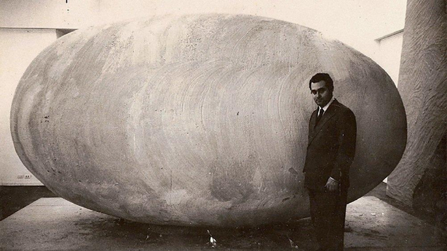 Federico Peralta Ramos posant devant sa sculpture d'un œuf géant en plâtre et en bois