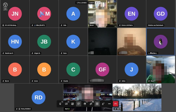 Screenshot einer älteren Jitsi virtuellen Sitzung. Die Teilnehmer werden als bunte Kreise mit ihren Initialen dargestellt, oder falls eine Kamera aktiv ist wird auch wer oder was hier dargestellt.