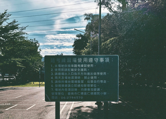 Sign with rules for using a practice/driving area, including safety instructions and contact information.