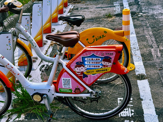 这是多辆共享自行车在街道上的停放区，其中一辆自行车上有彩色贴纸和二维码。