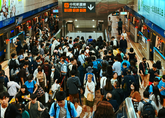 Crowded subway station with many people waiting on the platform for the Zhonghe-Xinlu Line.