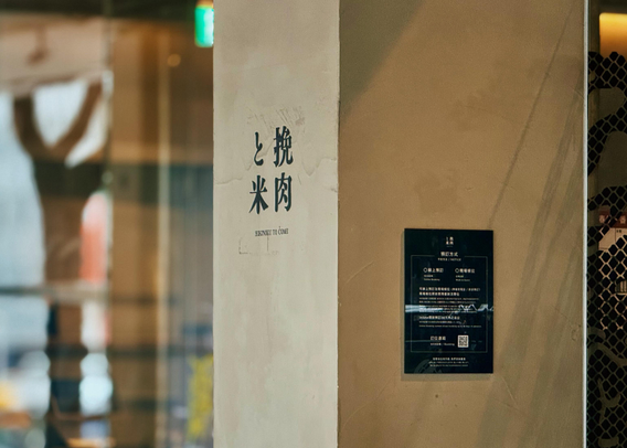 墙上有竖排的中文标志，上写“挎肉米”，旁有英文“HUNGRY TO COME”。