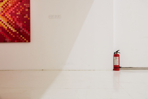 Part of a painting and a fire extinguisher in a museum