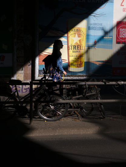 Diagonal light, a beer advert, a person walking through the scene,