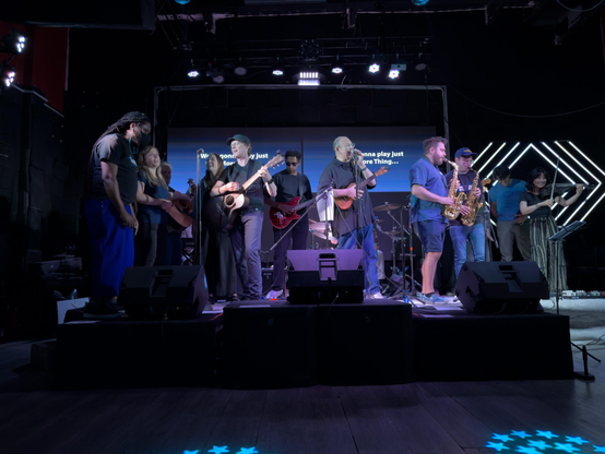 A stage full of people singing and playing instruments.
