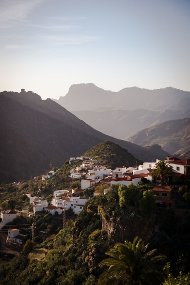 A small village with white houses and a mountainous landscape in the background
