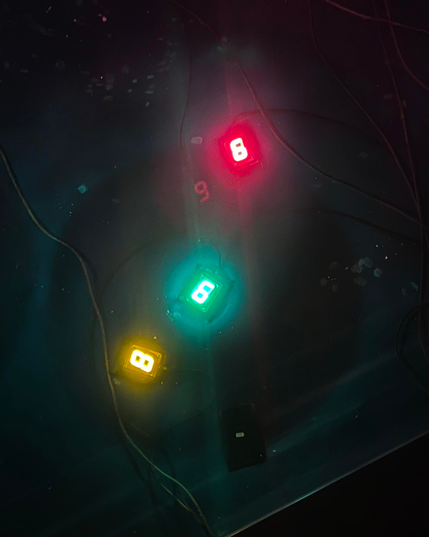 Drei Neonziffern leuchten im Wasser: eine gelbe 8, eine grüne 9 und eine rote 6.