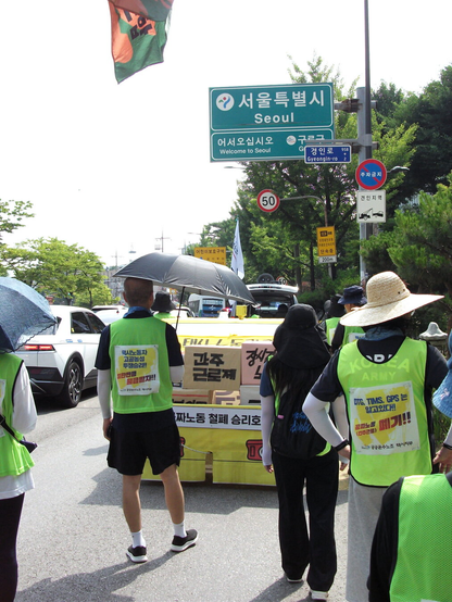 서울특별시로 진입하는 행진대오. “서울특별시” “어서오십시오, 구로구” 등 교통표지판이 보인다.