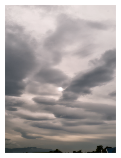 An overcast sky filled with dramatic, heavy gray clouds, with the sun faintly peeking through above a dark, silhouetted horizon. - Google Gemini 3.1 Pro Preview