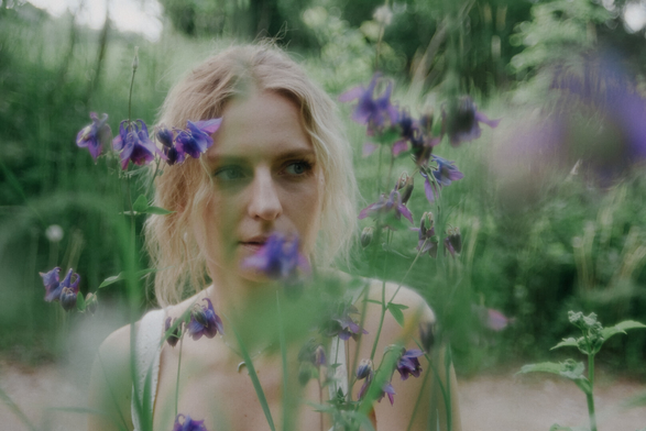 Photo portrait of a woman surrounded with flowers.