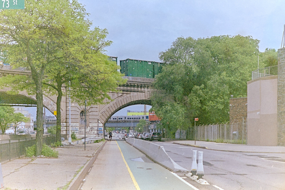 LIRR's freight train on a viaduct, with an LIRR passenger train in the distance.