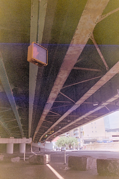 Beneath a giant viaduct, focusing on a pedestrian signal