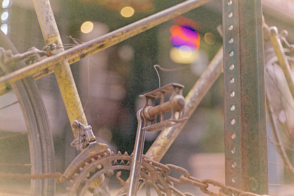 Closeup of a rusty bike by a street sign pole