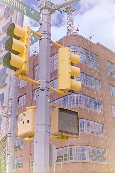Traffic lights in front of an old industrial building with red bricks and large glass windows